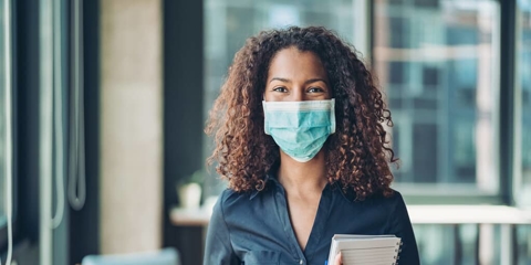 a woman wearing a mask in an office
